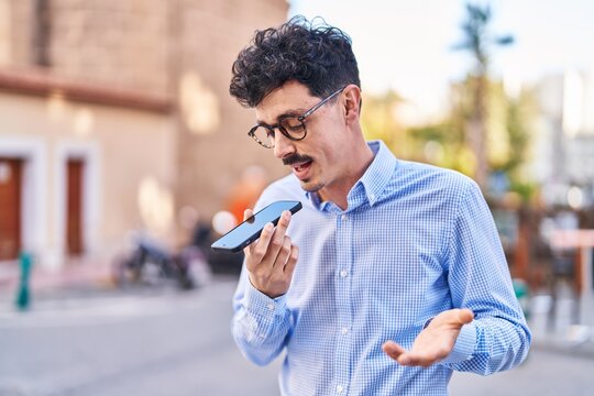Young caucasian man talking on the smartphone with serious expression at street