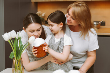 Obraz na płótnie Canvas Christ is risen! grandmother, mother and child with Easter cakes are preparing for the holiday