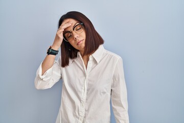 Young hispanic woman standing over white background worried and stressed about a problem with hand on forehead, nervous and anxious for crisis