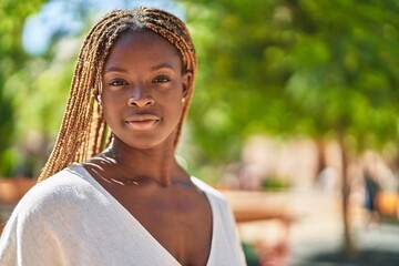 African american woman standing with serious expression at park