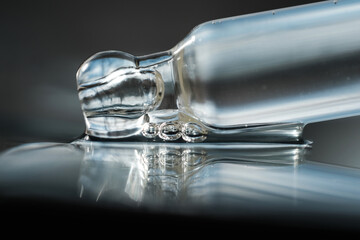 Glass pipette with air bubbles. Care cosmetics with peptides, ceramides, retinol molecules. Oil or hyaluronic or polyglutamic acid .