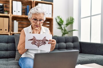 Senior grey-haired woman psychologist doing online rorscharch test at psychology center