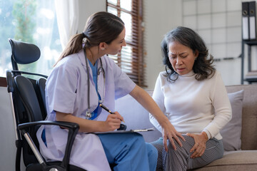 Obraz premium Female doctor examining the knee of an elderly Asian female patient.
