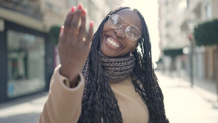 African woman smiling confident asking to come at street