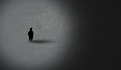 man silhouette stands in a light spot against darkness. Light and Dark Side. Surreal Concept. loneliness and Solitude 