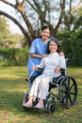 Asian nurse or physiotherapist caring for elderly woman sitting wheelchair
