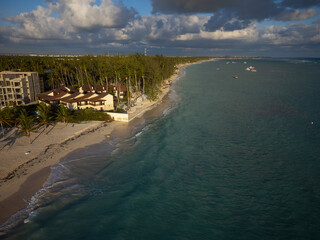 Seaside resort. Hotel, bungalow among palm forests on the sandy seashore. Clear turquoise sea....