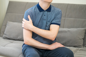 Man with pain in shoulder at home