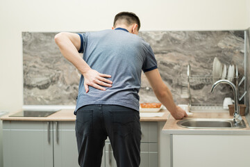 Back pain, kidney inflammation, man suffering from backache at home