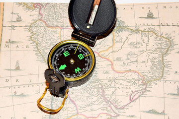 Army compass lies on an old physical map