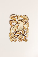 Dry slices of porcini as creative pattern, dehydrated food boletus mushrooms, top view, flat lay, beige background, minimal style. Natural food ingredient forest white mushroom, healthy eating