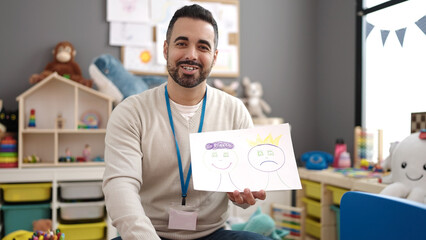 Young hispanic man working as teacher having emotion therapy at kindergarten