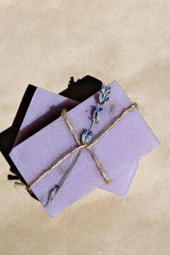 Lavender handmade soap with a branch of dried natural lavender on craft paper. Vertical image, flat lay, copy space.