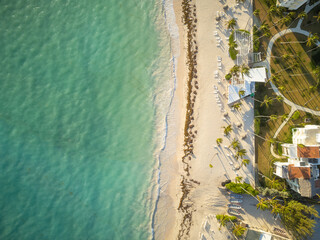 Beautiful sea beach. Shooting from a drone. Clear emerald sea. On the beach there are hotels, bungalows among palm trees. Well maintained walking paths. Business, tourism, recreation.