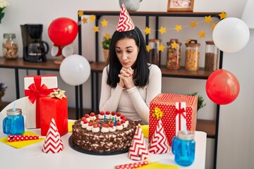 Young caucasian woman celebrating birthday sitting on table at home