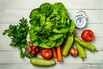 
Diet time. Food clock. Healthy food concept with vegetables on wooden table