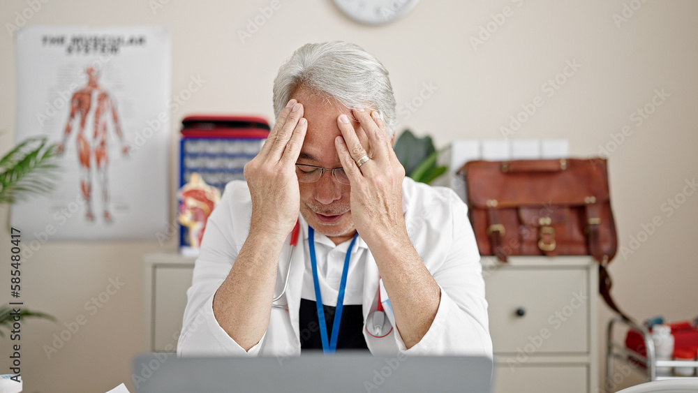 Canvas Prints Middle age man with grey hair doctor stressed working at clinic