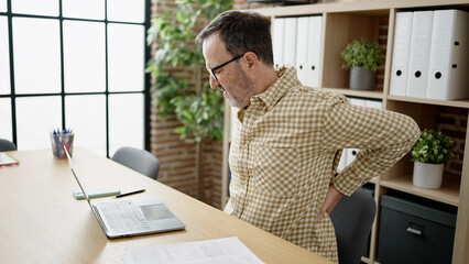 Middle age man business worker suffering for backache at office