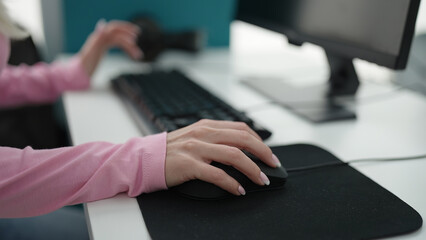 Young blonde woman student using computer studying at library university