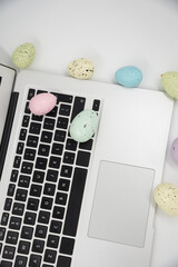Computer with blank empty screen on white background of easter eggs. Space for text. Happy Easter! 