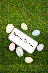 Phone with white screen with easter greeting on easter egg background