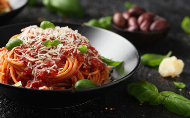 Italian marinara sauce spaghetti pasta served with fresh basil, olives and pecorino cheese