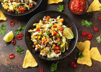 Mexican style salad of black beans, lentils, corn, tomato and lettuce with a salsa and tortilla chips