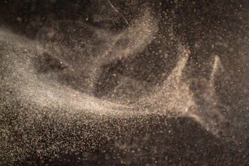 Organic dust particles floating on a light beam on black background. Glittering sparkling flickering overlay. High quality photo