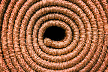 Rolled up carpet, orange colored spiral carpet texture, close up