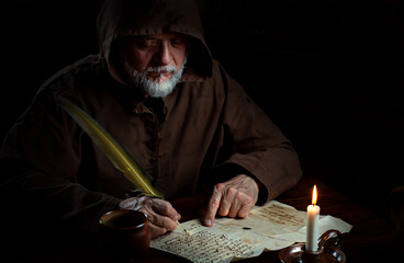 Old monk in the Middle Ages writes message
