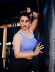 Indian Boxer Girl, Gym Girl standing with Boxing Bag looking Confident and strong.