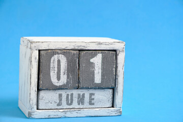 Calendar for June 01 made wooden cubes standing blue background. With empty space for text.