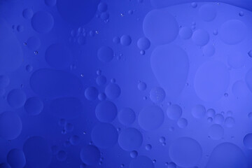 Blue abstract background with oil circles, streaks and gradient.