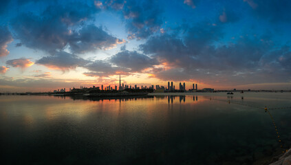 Sunrise over Dubai skyline. Wide angle photo with amazing color sky clouds over Dubai skyscraper buildings. Travel to United Arab Emirates.