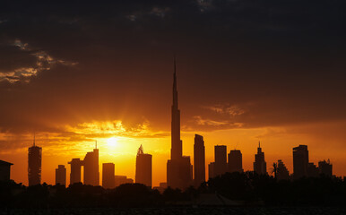Fototapeta na wymiar Amazing silhouette sunrise sky in Dubai, view to Burj Khalifa and the entire skyline with modern skyscrapers buildings. Rays of sun bursting in spectacular sunrise landscape in United Arab Emirates.