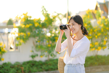 Portrait of asian woman traveler using camera at street of Bangkok, Thailand. Asia summer tourism vacation concept