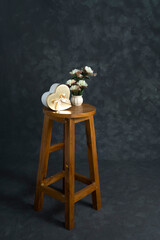 Studio backdrop image, Beautiful Gift box with flower on a wooden stool isolated on dark background