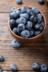 Fresh blueberry in wooden bowl. Concept of healthy and dieting eating.