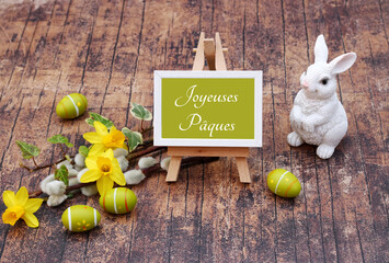 Carte de Pâques Joyeuses Pâques. Jonquilles et branches avec des lapins de Pâques et des œufs....