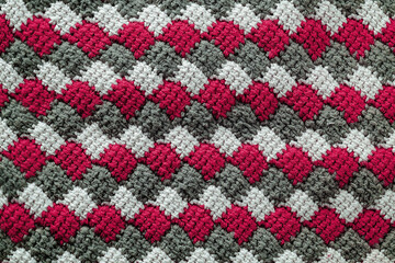 Tunisian crochet fabric. Fuchsia white grey knitted background. Crochet tunisain entrelac.