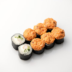 Baked maki sushi rolls set with scrambled eggs, crab, cream cheese, cucumbers and and herbs. Japanese, Asian cuisine. Seafood dish. White background. Top view. Soft focus. Copy space. 