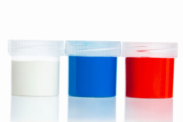Multi-colored jars with gouache blue, white and red. Hobbies and creativity. Isolated on white...