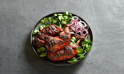 Tandoori chicken served with cilantro and onion