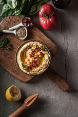 hummus with chickpea and chili on a wooden board
