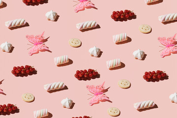 Cookies, lollypops, bonbons and berry fruit, creative candy pattern against pastel pink background. Summer aesthetic idea.