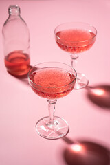 glass of rose wine on a pink background