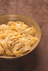 Fettuccine, tagliatelle, in creamy garlic sauce, Italian traditional cuisine, pasta carbonaro,