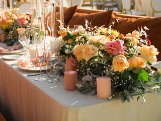 Table at luxury wedding reception event. Beautiful flowers on table and serving dishes and glasses and decoration