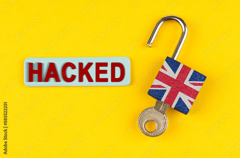 Poster on the yellow surface is an open lock with a key and a sticker with the inscription - hacked