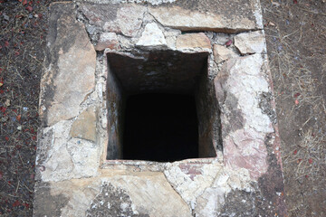 Vacation destination Chios Greece: Lost Places Lovokomeio Leper Colony. Hole or shaft in the ground, maybe square well or cystern entrance, bricked